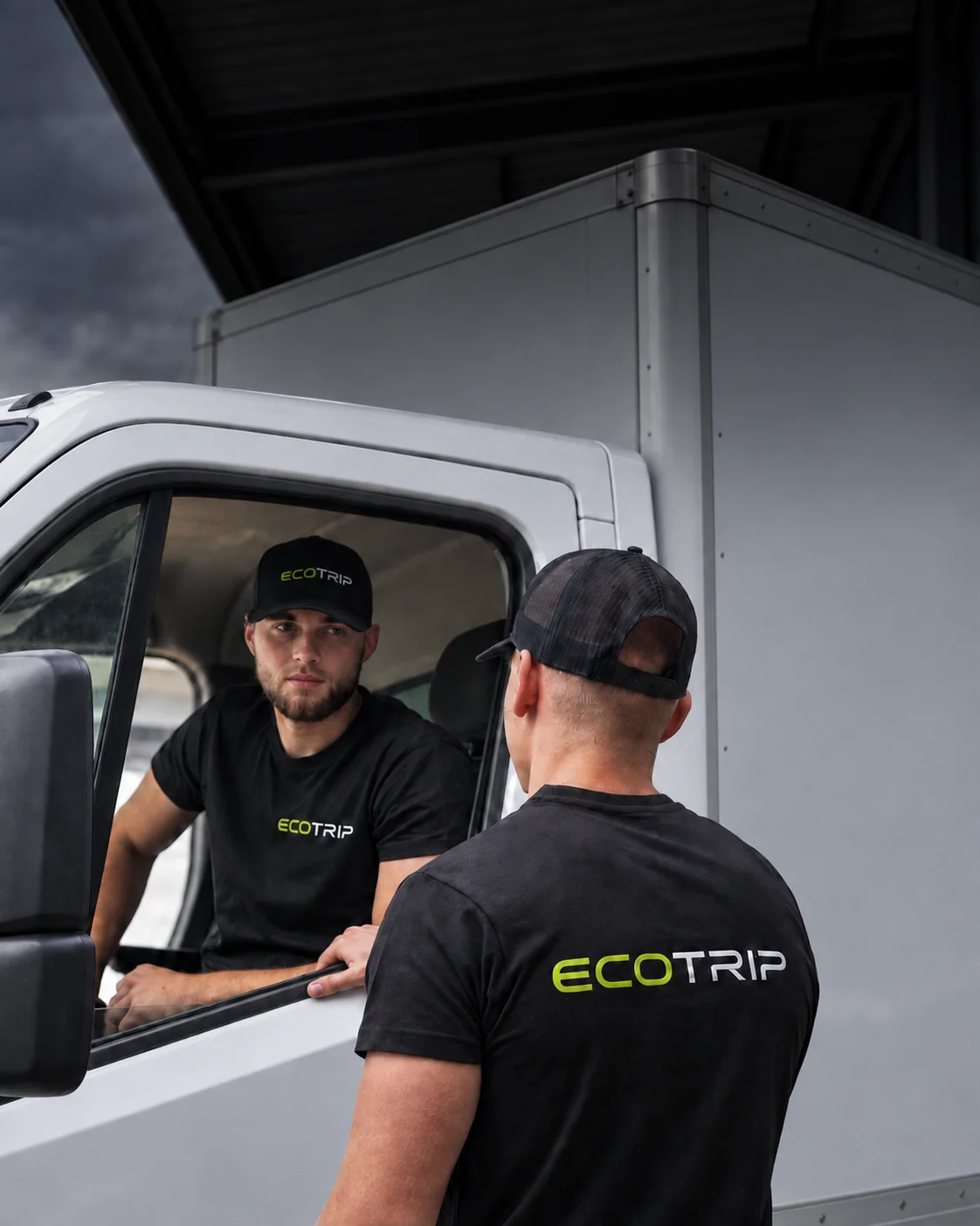 Two EcoTrip staff discussing work beside a vehicle cab, with the cargo body visible behind. Illustration.